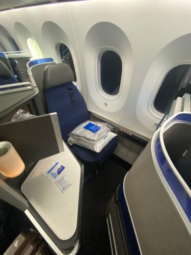 United Polaris 787 review photo showing window seat setup with Saks bedding and amenity kit on the 787-10 from Honolulu to Chicago